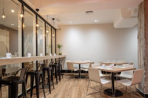 ビルバオにあるEurostars Indautxuのテーブルと椅子とバーのあるレストラン