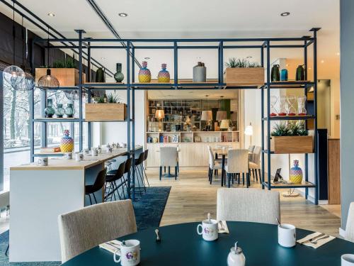 a restaurant with tables and chairs and a bar at Mercure Hotel Hannover Mitte in Hannover