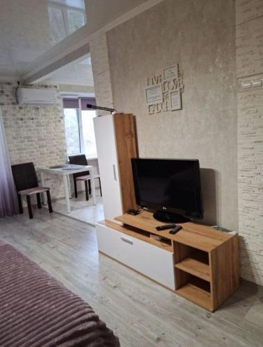 a living room with a television and a refrigerator at Апартаменти проспект Богоявленський 20 біля Автовокзалу in Mykolaiv