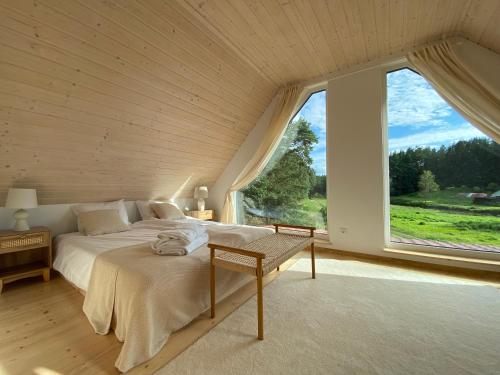 a bedroom with a bed and a large window at Stodoła Drwęck in Drwęck