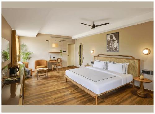 a bedroom with a white bed and a living room at Hotel AV Ganges Varanasi - Walking Distance From BABA VISHWANATH TEMPLE #Wifi #Fully Air Conditioned & Spacious Rooms - Best Budget Hotel In Varanasi in Varanasi