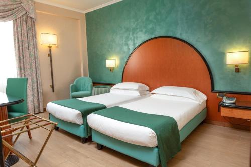 a hotel room with a large bed and two chairs at Hotel Principe in Pomezia