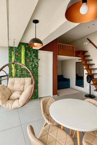 a dining room with a white table and chairs at Lindo Studio a 600m da praia in Guarujá