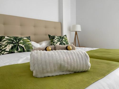 a bed with a white blanket on it with two teddy bears at Espectacular Y Amplio Las Américas in Playa de las Americas