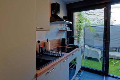 a kitchen with a sink and a counter with a window at Instinct Sauvage - Nature & Jacuzzi privatif in Verdun