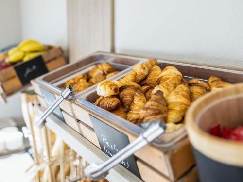 uma bandeja de produtos de pastelaria e croissants numa mesa em ibis Budget Charleroi Airport em Charleroi