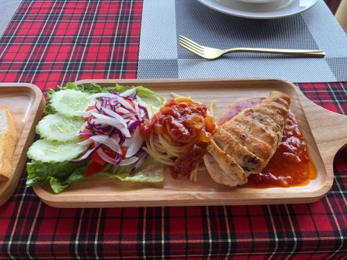 un plato de comida con un sándwich y ensalada en una mesa en Intimate Riverside Resort, en Vang Vieng