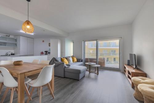 a kitchen and living room with a table and a couch at Iva's Panoramic Sesimbra in Sesimbra