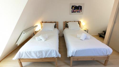 two twin beds in a room with stairs at Le Refuge - Petite maison de village in Kaysersberg