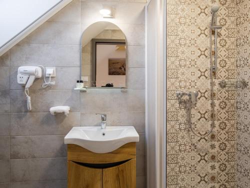 a bathroom with a sink and a shower at STADIUM HOME Panzió in Németbarnag