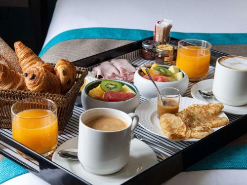 una bandeja de alimentos para el desayuno y bebidas en una mesa en Hotel Mercure La Baule Majestic, en La Baule