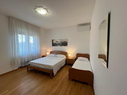 a bedroom with two beds and a window at GIODE X Borgo Roma II in Verona