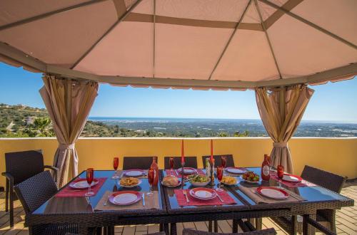 a table with plates of food on top of a balcony at Villa Panoramica by Algarve Holidays in Estói