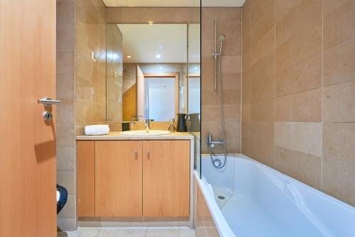 a bathroom with a tub and a sink and a bath tub at Expo Studio in Lisbon