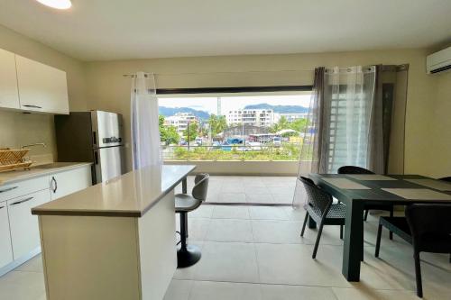cocina y comedor con mesa y ventana en Kavai City - brand new 2 bedr 2bth AC - Wi-Fi - parking, en Papeete