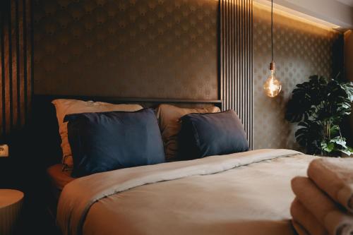 Un dormitorio con una cama grande con almohadas azules. en Luxury Harbour Apartment with Sauna and Jacuzzi, en Medemblik