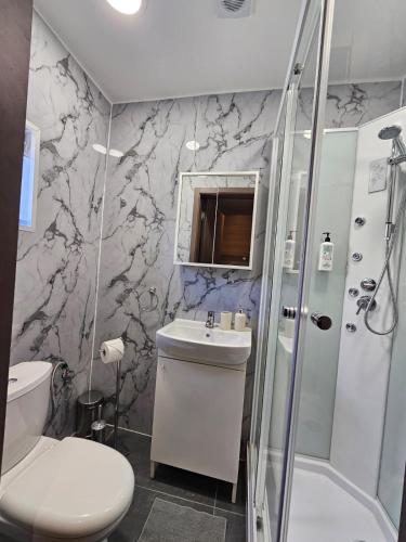 a bathroom with a toilet sink and a shower at Mingles Suites in Il-Gżira