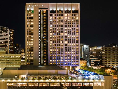 a tall building with lights in a city at night at Sofitel Brisbane Central in Brisbane