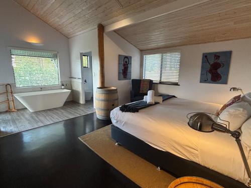 a bedroom with a large bed and a bath tub at Valley Cottage, Treeton winery, Margaret River in Cowaramup