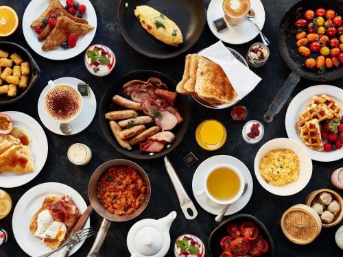 a table with many plates of breakfast foods and drinks at Sofitel Brisbane Central in Brisbane