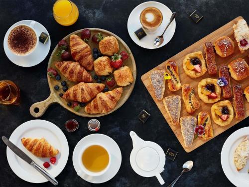 a table topped with plates of pastries and cups of coffee at Sofitel Brisbane Central in Brisbane
