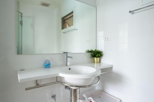 a white bathroom with a sink and a mirror at Boathouse Hua Hin Condo in Ban Bo Fai