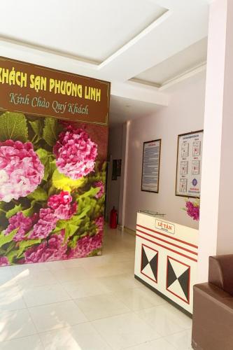 a sign in the lobby of a building with pink flowers at Phuong Linh Hotel in Bảo Lạc