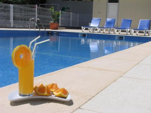 an orange juice dispenser next to a swimming pool at Pantanha Apartment 02 by Trip2Portugal in Nelas