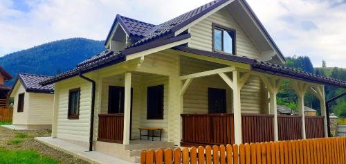 a small house with a fence in front of it at Котедж Маєток Ярини in Krivopolʼye