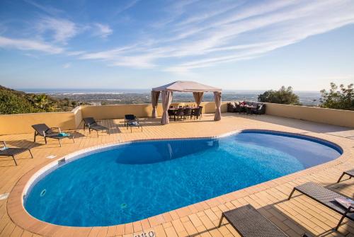 una piscina con sillas y un cenador en Villa Panoramica, en Estói