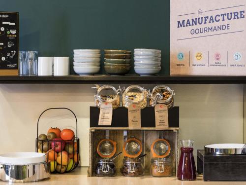 un mostrador con tazones y platos en un estante en Aparthotel Adagio Annecy Centre, en Annecy