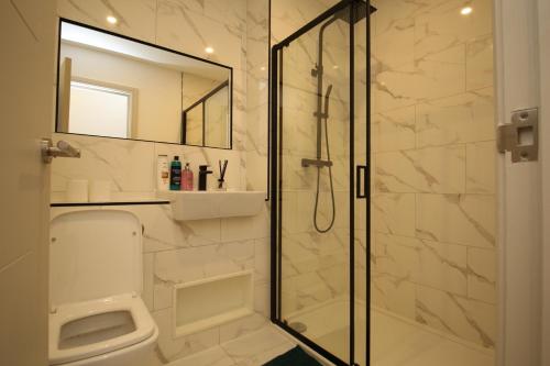 y baño con ducha, aseo y espejo. en AMD Hotel Modern Comfort in the Heart of Sutton SM1, en Sutton