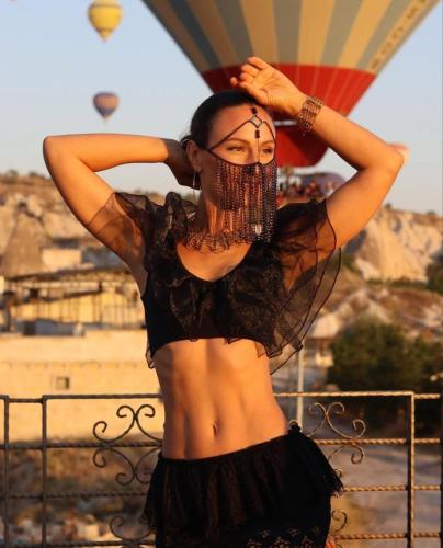 a woman standing in front of a hot air balloon at Virtus Cappadocia Hotel Göreme in Goreme