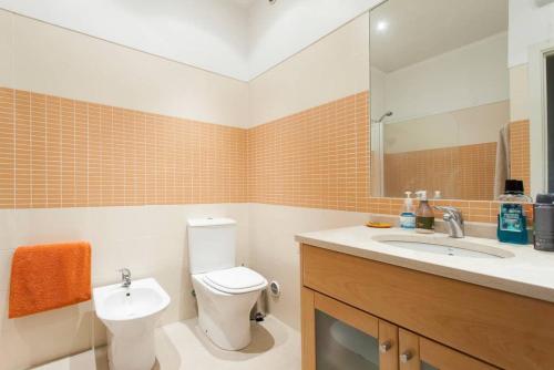 a bathroom with a toilet and a sink and a mirror at Quinta das Conchas Apartment by Trip2Portugal in Lisbon