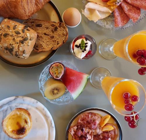 a table topped with plates of breakfast foods and drinks at Bed and Breakfast 't Teutenhuys Eersel in Eersel