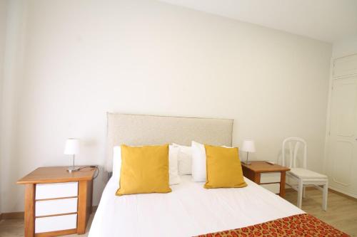 a bedroom with a large bed with yellow pillows at Quinta das Conchas Apartment by Trip2Portugal in Lisbon