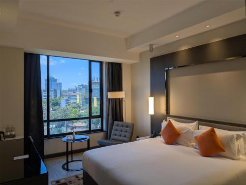 a hotel room with a bed and a large window at Best Western Premier Westlands in Nairobi