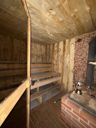 a wooden room with a bench and a fireplace at Domek na Mazurach in Pisz
