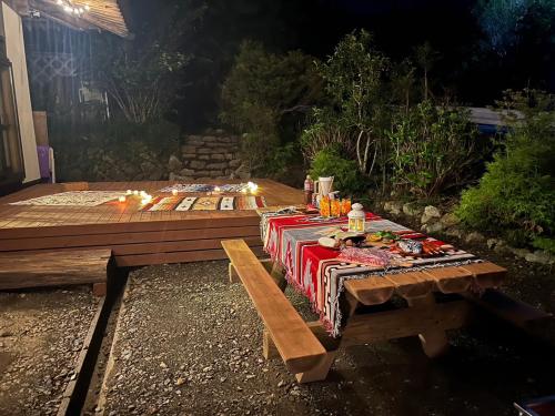 une table de pique-nique dans une cour arrière la nuit avec dans l'établissement 築150年の古民家ゲストハウスひとたび, à Iwaki