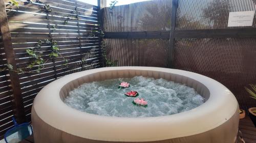 a hot tub with two flowers in it with aificialificialificialificialificialificial at Countryside home Villa Luna with Private Yard & Jacuzzi in Alora