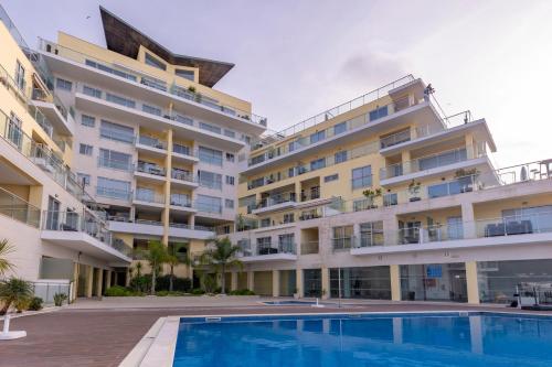 an apartment building with a swimming pool in front of it at Sea Sound Apartment by Trip2Portugal in Sesimbra