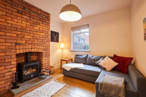 ein Wohnzimmer mit einer Couch und einem gemauerten Kamin in der Unterkunft Stylish Coastal 3-Bed Retreat in Saltburn in Saltburn-by-the-Sea