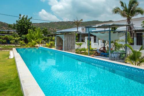 a swimming pool in front of a house at Chilli Fields in Phan Rang