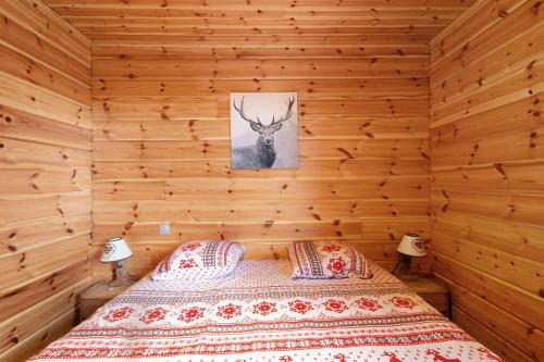 a bedroom with a bed in a wooden wall at Chalet Les Lupins in Les Angles