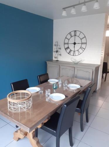 tavolo da pranzo con sedie e orologio sul muro di L'Avre de Roye a Roye