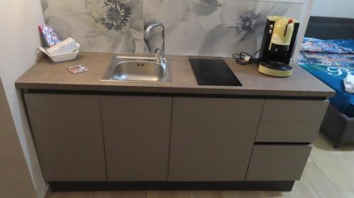 a kitchen counter with a sink next to a bed at Le Casette in San Giorgio a Cremano