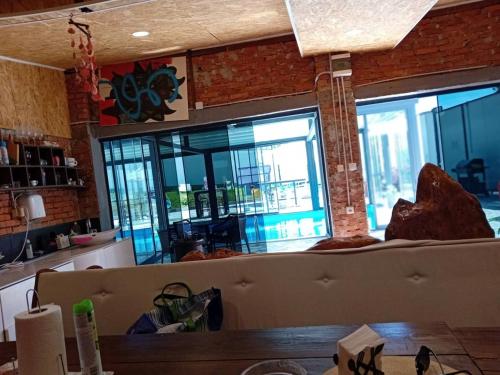 a dining room with a table and some windows at Gyps Vikendica with Swimming Pool and Sauna 2 in Tuzla