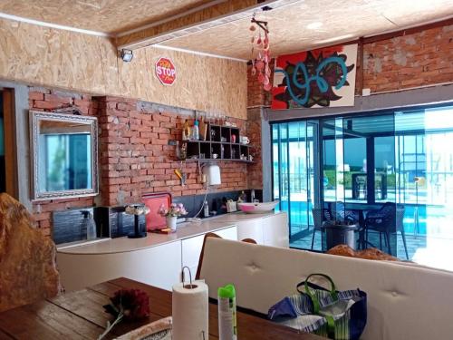 a kitchen with a brick wall and a table at Gyps Vikendica with Swimming Pool and Sauna 2 in Tuzla
