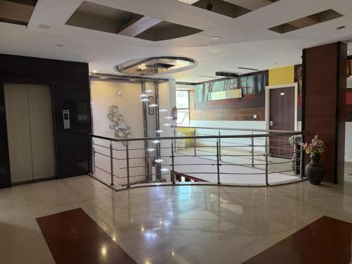 a lobby with a staircase in a building at Vaishali Deluxe Comfort in Tumkūr