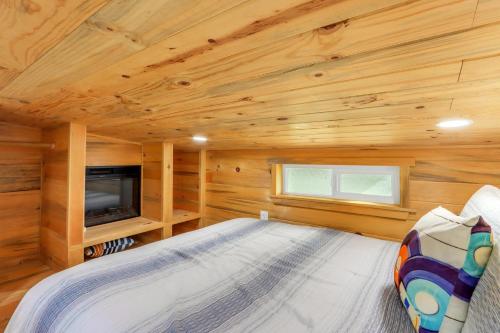 a log cabin bedroom with a bed and a tv at Arbor House of Dripping Springs - Harmony Hollow in Dripping Springs